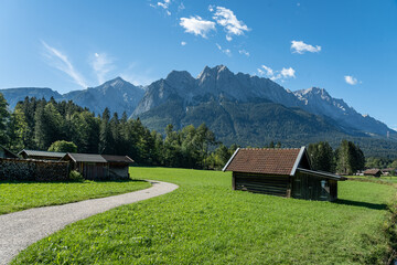 view on wetterstein mountains, a meadow and a wooden hut in the foreground