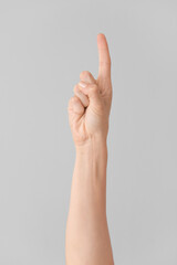 Hand showing letter Z on grey background. Sign language alphabet