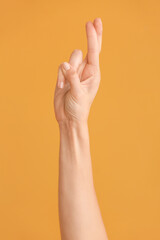 Hand showing letter R on color background. Sign language alphabet