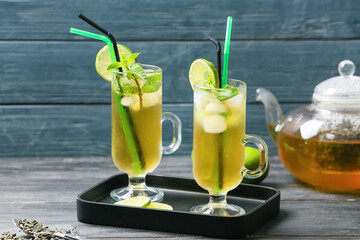 Cups of tasty cold ice tea on table