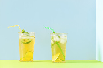 Glasses of tasty cold ice tea on color background
