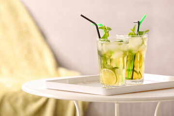 Glasses of tasty cold ice tea on table in room