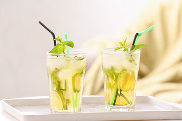 Glasses of tasty cold ice tea on table in room