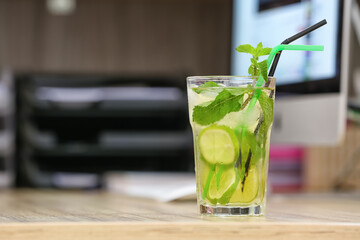 Glass of tasty cold ice tea on table in room
