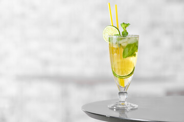 Glass of tasty cold ice tea on table in room