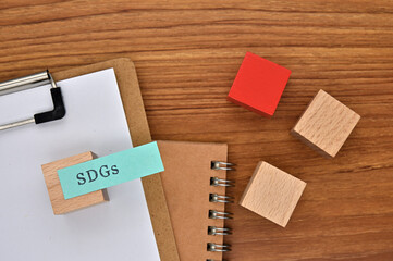 The words "SDGs" written on sticky note with clipboard in diagonal angle.