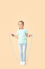 Cute little girl jumping rope against color background