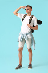 Male tourist on color background