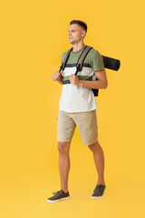 Male tourist on color background