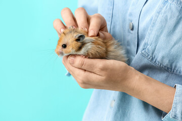 Woman with cute funny hamster on color background, closeup