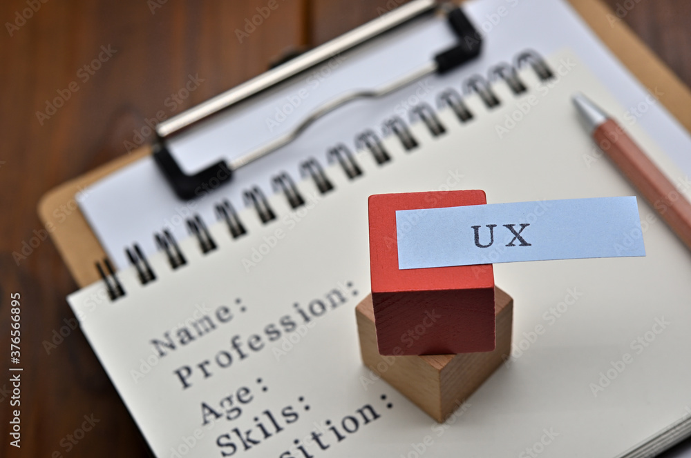 Poster a note with the user's persona written on it is placed on a clipboard along with a pen. a sticky not