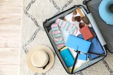 Open packed suitcase on floor in room. Travel concept