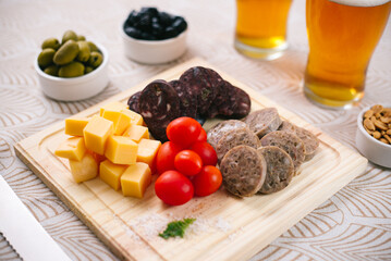 Picada de fiabres con tomate cherry, queso, morcilla vasca, queso de cerdo, acompañado de aceitunas con cerveza fría