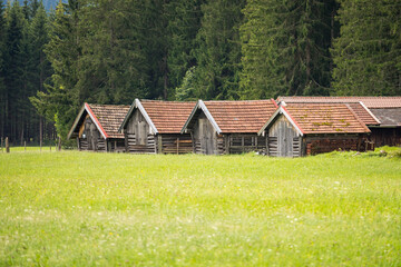 Fototapeta na wymiar view on wetterstein mountain panorama and wooden houses on a green meadow near mittenwald