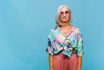 middle age cool woman looking happy and friendly, smiling and winking an eye at you with a positive...