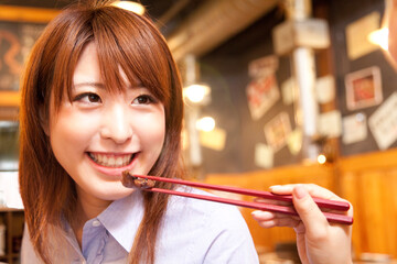 焼肉を食べさせてもらう女性 © Paylessimages