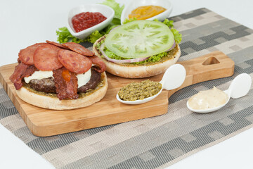 Slice Of Hamburger Bun With Salami, meat, And Sauce; Ready To Assemble The Burger.