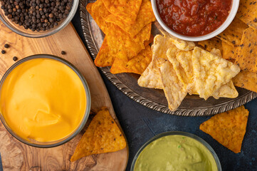 Snacks and chips with dip, salsa, ketchup and sauces, top view, snack for beer or big parties