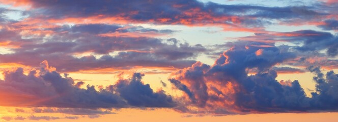 Epic dark sunset sky above the sea shore after the storm. Dramatic glowing colorful red clouds, natural texture, background. Fickle weather, climate change, ecology. Panoramic view