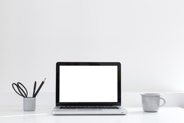 Fototapeta premium Desk with laptop computer, coffee mug and supplies. Stylish minimalistic workspace.
