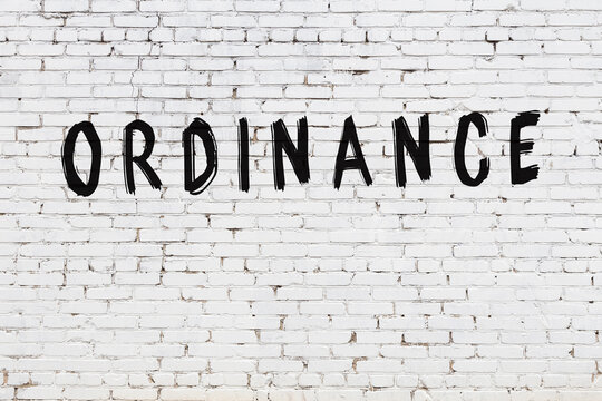 Inscription ordinance painted on white brick wall