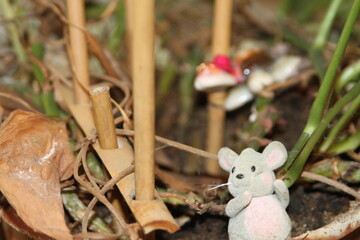 Obraz premium Toy mouse on a plant with spokes and toy turtle in the backround