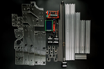 a set of parts for a laser machine on a black background, silver backlight, flat lay arduino board...