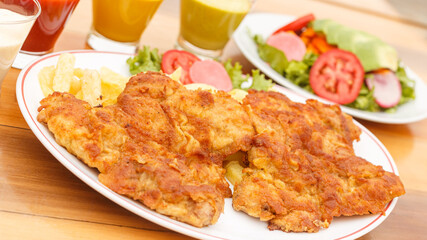 chicken milanesa with french fries and salad - peruvian food