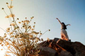 .Beautiful brunette girl in a dress meditates at sunset in the mountains, climb the mountains.