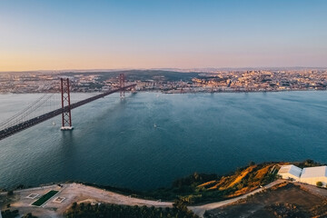 View of the city from above, the statue of Christ on the banks of the Tagus River, narrow streets and roofs of houses with red tiles Lisbon.