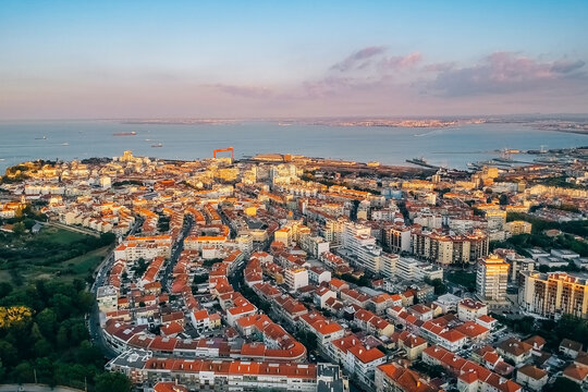 View of the city from above, the statue of Christ on the banks of the Tagus River, narrow streets and roofs of houses with red tiles Lisbon.
