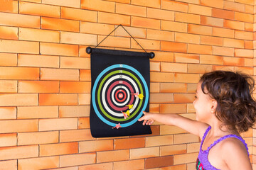 Menina feliz brincando de arremesso de dardos