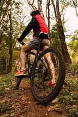 Fototapeta na wymiar Biker in the jungle. Closeup view of man's back on his bike.