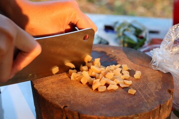 Chef cutting pickles on a cutting board