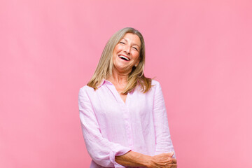 middle age pretty woman laughing shyly and cheerfully, with a friendly and positive but insecure...
