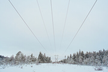 Power transmission line in winter snowy day. Electricity transportation