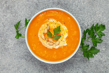 Pumpkin soup and various vegetables on a dark background. Top view.