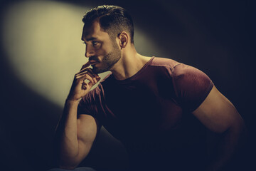 Fashion portrait of brutal strong man dreaming on black background