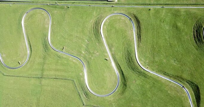 Amazing drone aerial view of a summer bobsleigh track. Passo della Presolana. Bergamo, Italy. Natural contest. Leisure time. Beautiful nature with green meadow. Vertical landscape