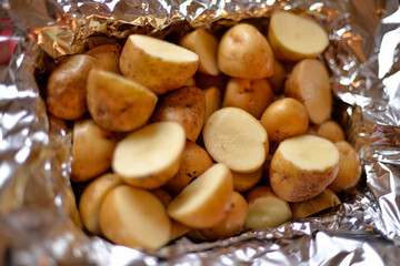 the process of cooking potatoes wrapped in foil, on the grill at home, with your own hands, on an autumn day
