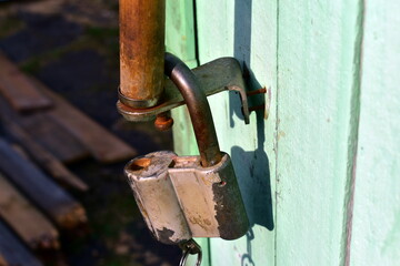 old lock with a key hanging on the door handle