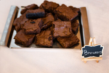 Brownies on a metal tray on the table.