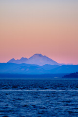 Mt. Baker glows in the colors of dusk over the ocean and Puget Sound