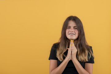 Studio shot of an attractive teenager girl with braces begs for something