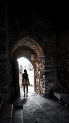 Fototapeta na wymiar Dark-skinned young attractive woman in backlight at the exit in the arch