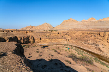 Fototapeta na wymiar Tourist tent in a mountainous desert area by a small river