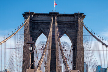New york city manhattan to brooklyn bridge with use flag on top sand suspension cables