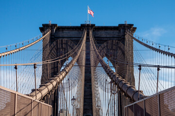 Fototapeta premium New york city manhattan to brooklyn bridge with use flag on top sand suspension cables