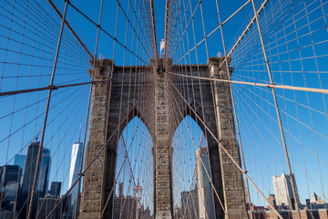 Fototapeta na wymiar New york city manhattan to brooklyn bridge with use flag on top sand suspension cables