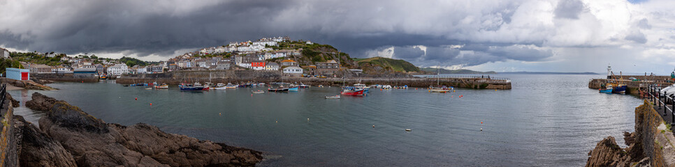 Fototapeta na wymiar Panoramic view of the harbour at Mevagissey in Cornwall on a dramatic stormy summer afternoon
